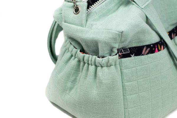 Présentation de la poche côté du sac à langer vert tilleul.