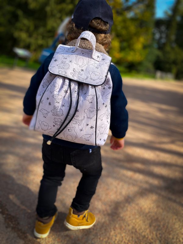 Petit garçon en balade vu de dos, portant sac à dos Oursons.